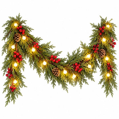 Christmas garland with red berries, pinecones and glowing globe lights arranged in a swag on white background