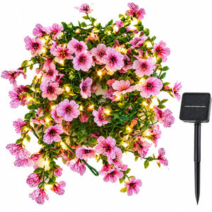 Artificial violet flower solar fairy lights with pink blossoms and ground stake solar panel on white background